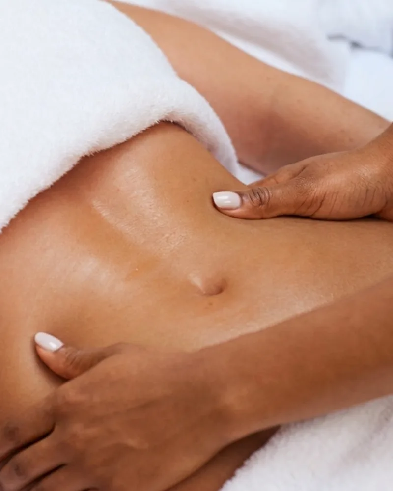 Light, precise strokes along the abdomen during a lymphatic drainage session